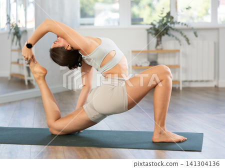 Lover of active lifestyle on yoga mat perform doing Anjaneyasana in gym 141304136