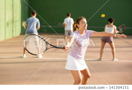 Woman playing frontenis on outdoor pelota court Woman playing frontenis on outdoor pelota court 141304151