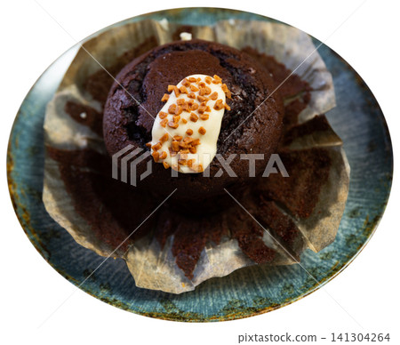 Chocolate tulip muffin topped with cream and caramel sprinkles 141304264