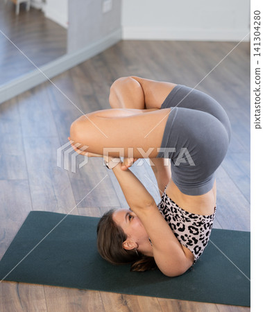 Young woman practicing vinyasa yoga in studio Young woman practicing vinyasa yoga in studio 141304280