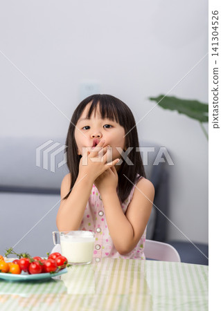 Playful Asian little girl making funny face while eating, child behavior and emotional expression concept Playful Asian little girl making funny face while eating, child behavior and emotional expression concept 141304526