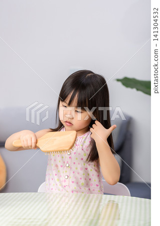 Little Asian Girl Brushing Hair at Home, Child Self Care Routine and Daily Hygiene Concept Little Asian Girl Brushing Hair at Home, Child Self Care Routine and Daily Hygiene Concept 141304532