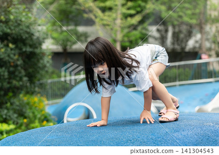 Asian Little Girl Climbing Wall at Outdoor Playground Asian Little Girl Climbing Wall at Outdoor Playground 141304543
