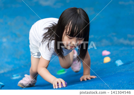 Asian Little Girl Climbing Wall at Outdoor Playground Asian Little Girl Climbing Wall at Outdoor Playground 141304546
