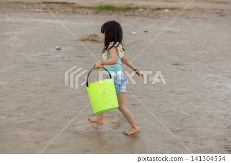 An Asian girl playing on the beach by the river in summer. An Asian girl playing on the beach by the river in summer. 141304554