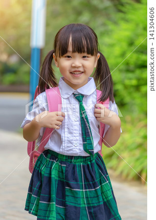 Happy Asian primary school girl walking with a pink backpack, smiling student ready for school. Happy Asian primary school girl walking with a pink backpack, smiling student ready for school. 141304606