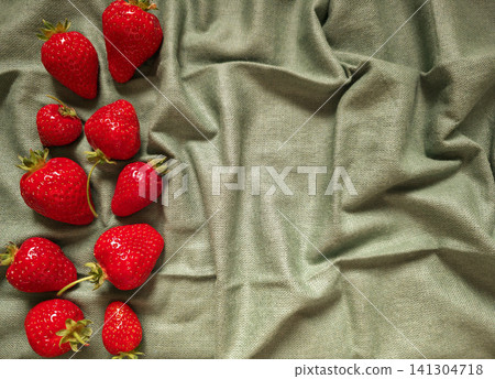 Fresh ripe strawberries arranged diagonally on textured sage green linen with copy space. Concept of summer harvest and healthy eating Fresh ripe strawberries arranged diagonally on textured sage green linen with copy space. Concept of summer harvest and healthy eating 141304718