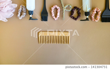 A wooden comb, silk scrunchies, a rhinestone clip and spray bottle are grouped on beige with wide copy space. Concept of sustainable haircare and zero waste beauty A wooden comb, silk scrunchies, a rhinestone clip and spray bottle are grouped on beige with wide copy space. Concept of sustainable haircare and zero waste beauty 141304731