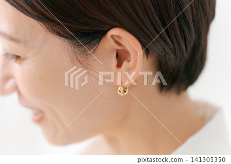 戴著耳環的女人的耳朵 戴著耳環的女人的耳朵 141305350