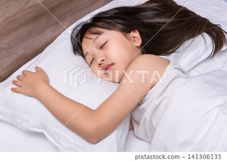 Asian little girl sleeping peacefully in bed, healthy sleep and childhood rest concept Asian little girl sleeping peacefully in bed, healthy sleep and childhood rest concept 141306135