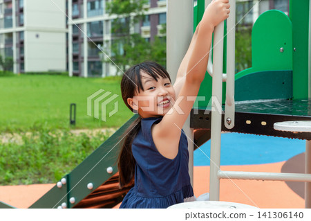 Happy Asian little girl playing on playground equipment, active childhood and outdoor fun concept Happy Asian little girl playing on playground equipment, active childhood and outdoor fun concept 141306140