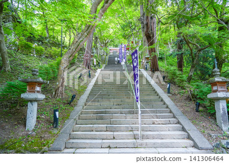 The stairs and banners at the entrance of Tanzan Shrine in Sakurai City, Nara Prefecture, amidst the beautiful fresh greenery. The stairs and banners at the entrance of Tanzan Shrine in Sakurai City, Nara Prefecture, amidst the beautiful fresh greenery. 141306464