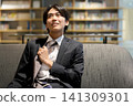 一位商人回家後摘下了領帶。 141309301