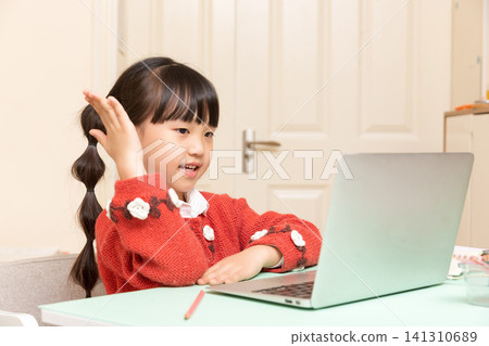 Happy Asian school girl raising hand during online class, e learning and virtual classroom concept, studying with laptop at home Happy Asian school girl raising hand during online class, e learning and virtual classroom concept, studying with laptop at home 141310689