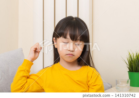 Asian girl cleaning ear with cotton swab child hygiene healthcare concept Asian girl cleaning ear with cotton swab child hygiene healthcare concept 141310742