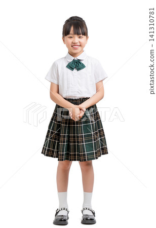 Full length portrait of a polite school girl standing with her hands clasped. 141310781