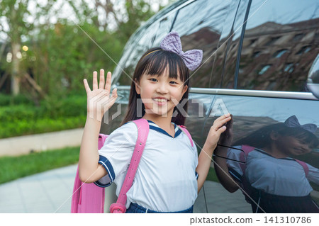 Asian schoolgirl with backpack waving near car, safe school commute and daily life concept 141310786