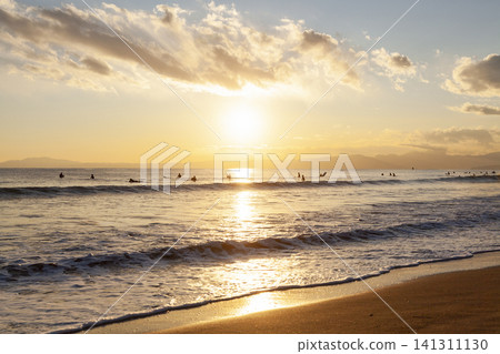 Shonan Kugenuma Beach: The sea and sandy shore illuminated by the setting sun. Shonan Kugenuma Beach: The sea and sandy shore illuminated by the setting sun. 141311130