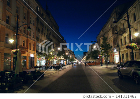 Piotrkowska street with historic buildings at night in Lodz. pedestrian avenue Piotrkowska street with historic buildings at night in Lodz. pedestrian avenue 141311462