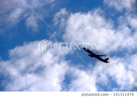 Airplane flying high in the blue sky filled with white clouds Airplane flying high in the blue sky filled with white clouds 141311478