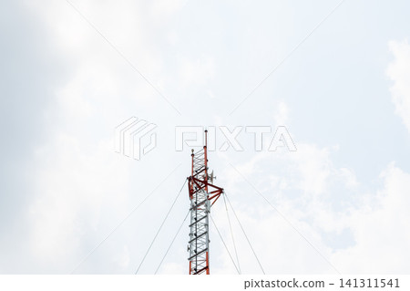 Telecommunication tower rising into blue sky light clouds Supporting wireless communication broadcasting network connectivity ample copy space 141311541