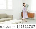 Woman holding a vase in the living room Woman holding a vase in the living room 141311787