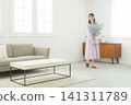 Woman holding a vase in the living room Woman holding a vase in the living room 141311789