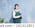 A woman with a smile wearing an apron A woman with a smile wearing an apron 141311851
