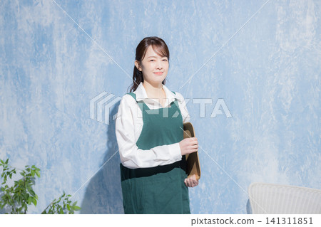 A woman with a smile wearing an apron A woman with a smile wearing an apron 141311851