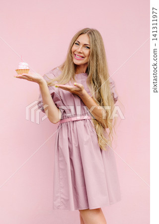 Woman In Pink Dress Holding Cupcake With Candle Woman In Pink Dress Holding Cupcake With Candle 141311977
