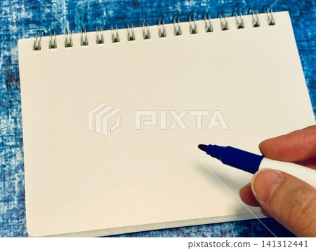 Hands writing something in a sketchbook Hands writing something in a sketchbook 141312441