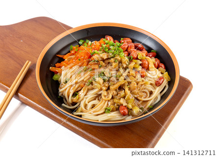 traditional Wuhan hot dry noodles with rich sesame paste, peanuts and pickled vegetables in a ceramic bowl. 141312711