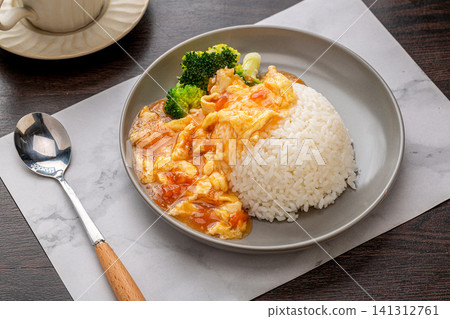 delicious Chinese stir-fried tomatoes and scrambled eggs served with white rice and green vegetables. 141312761