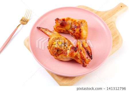 taiwanese style roasted chicken wing stuffed with flavorful fried rice, cut open and served on plate. taiwanese style roasted chicken wing stuffed with flavorful fried rice, cut open and served on plate. 141312796