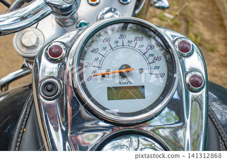 Close up of chrome motorcycle speedometer showing km scale with digital display, classic motorbike instrument concept Close up of chrome motorcycle speedometer showing km scale with digital display, classic motorbike instrument concept 141312868