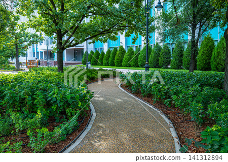 Curved walking path through manicured green park with trees and hedges in summer city, urban landscape design concept Curved walking path through manicured green park with trees and hedges in summer city, urban landscape design concept 141312894