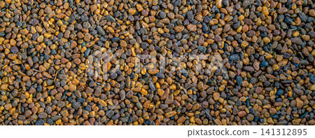 Close up texture of small brown golden gravel pebbles scattered on ground, natural landscaping and construction material concept Close up texture of small brown golden gravel pebbles scattered on ground, natural landscaping and construction material concept 141312895