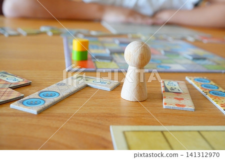 Parent-child playtime enjoying board games and wooden game pieces Parent-child playtime enjoying board games and wooden game pieces 141312970
