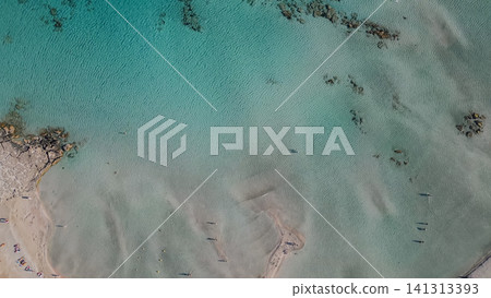 Horizontal top down aerial view of Elafonisi beach in Crete Greece with crystal clear turquoise sea water and tourists relaxing near sun umbrellas on pink sand Horizontal top down aerial view of Elafonisi beach in Crete Greece with crystal clear turquoise sea water and tourists relaxing near sun umbrellas on pink sand 141313393