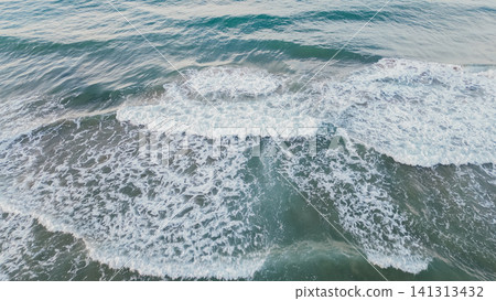 Horizontal top down aerial view of deep green ocean water with ripples and crashing white seafoam crests creating a beautiful natural background pattern Horizontal top down aerial view of deep green ocean water with ripples and crashing white seafoam crests creating a beautiful natural background pattern 141313432