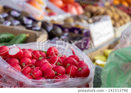 Fresh red radishes inside a plastic bag at a produce market, reflecting vibrant farm harvest colors and healthy eating concepts for local shopping and culinary ingredient sourcing Fresh red radishes inside a plastic bag at a produce market, reflecting vibrant farm harvest colors and healthy eating concepts for local shopping and culinary ingredient sourcing 141313798