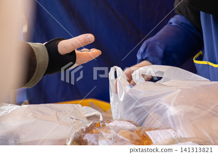 A customer hands metal coins to a street market vendor while purchasing fresh groceries in a plastic bag to illustrate daily small business transactions and local community commerce A customer hands metal coins to a street market vendor while purchasing fresh groceries in a plastic bag to illustrate daily small business transactions and local community commerce 141313821