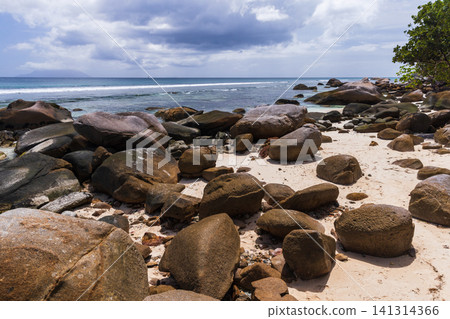 Tropical beach scene featuring large boulders and ocean water. Seychelles Tropical beach scene featuring large boulders and ocean water. Seychelles 141314366