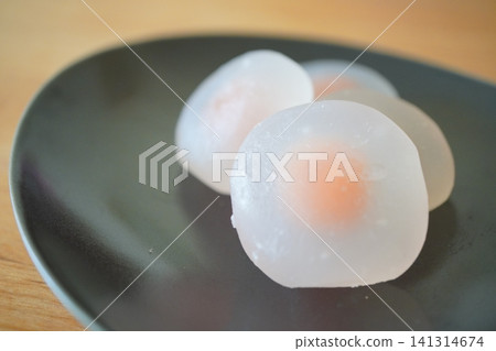 A close-up of a white fruit mochi that conveys its chewy texture. A close-up of a white fruit mochi that conveys its chewy texture. 141314674