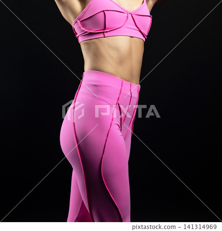athletic female body in pink sportswear on dark background, fitness woman, athletic girl torso athletic female body in pink sportswear on dark background, fitness woman, athletic girl torso 141314969