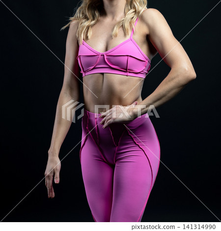athletic female body in pink sportswear on dark background, fitness woman, athletic girl torso athletic female body in pink sportswear on dark background, fitness woman, athletic girl torso 141314990