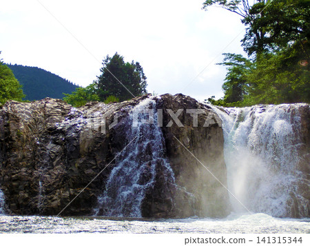 The scenery of a waterfall cascading down, sending up spray. The scenery of a waterfall cascading down, sending up spray. 141315344