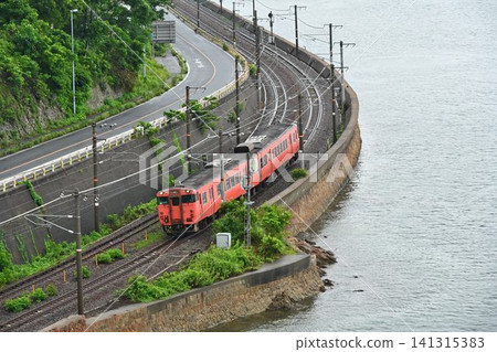 A KiHa 40 diesel railcar passing along the Sanyo Main Line and the Setouchi coastline, viewed from an aerial perspective from Ohata Bridge. A KiHa 40 diesel railcar passing along the Sanyo Main Line and the Setouchi coastline, viewed from an aerial perspective from Ohata Bridge. 141315383