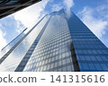 Low angle view of modern glass skyscraper against blue sky 141315616