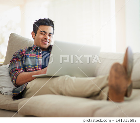 Man, laptop and home for internet connection with streaming service for free time, stress relief or resting. Male person, smile and couch with technology for online subscription, watching or blogging Man, laptop and home for internet connection with streaming service for free time, stress relief or resting. Male person, smile and couch with technology for online subscription, watching or blogging 141315692